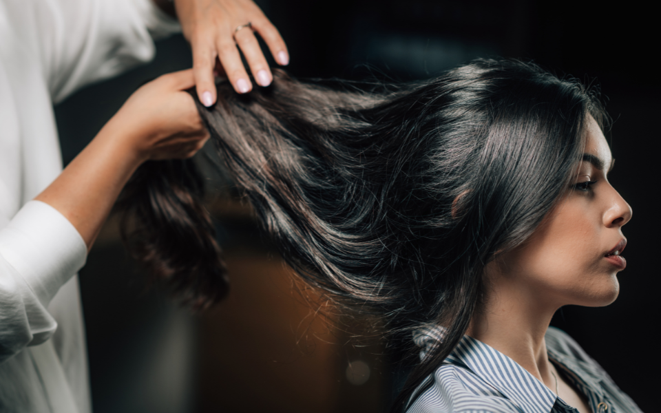 femme chevelure brune en train de se faire coiffer